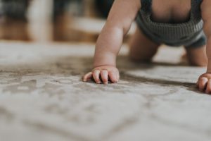 Professional Carpet Cleaning in Gold Coast Baby hands and feet shown crawling on a beige carpet - Who Who Carpet Cleaning & Pest Management 